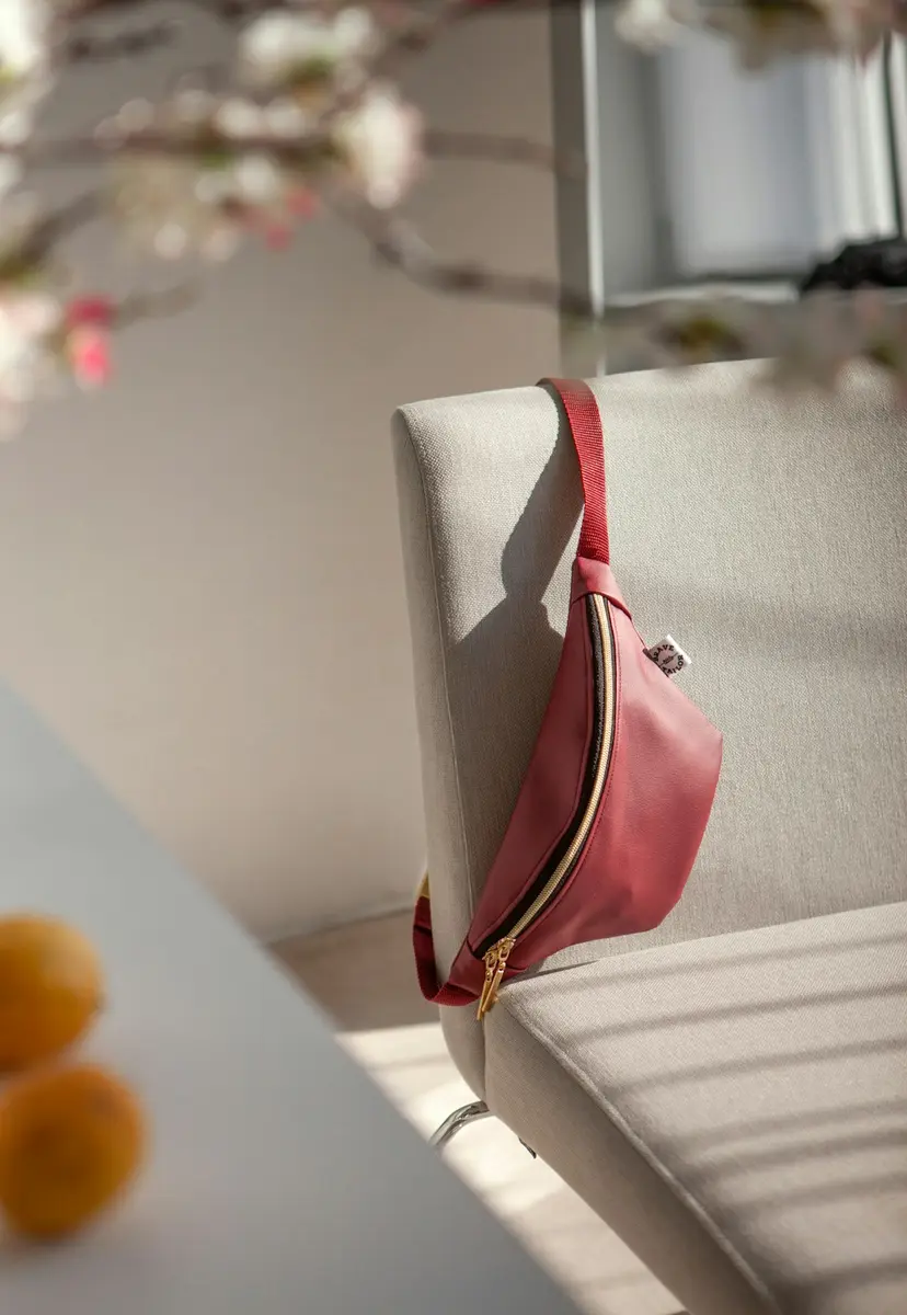 Cangurera rosa colgada de una silla